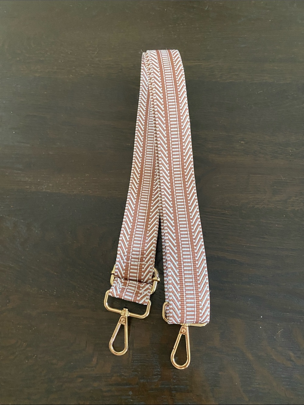 Brown and white crossbody bag strap.